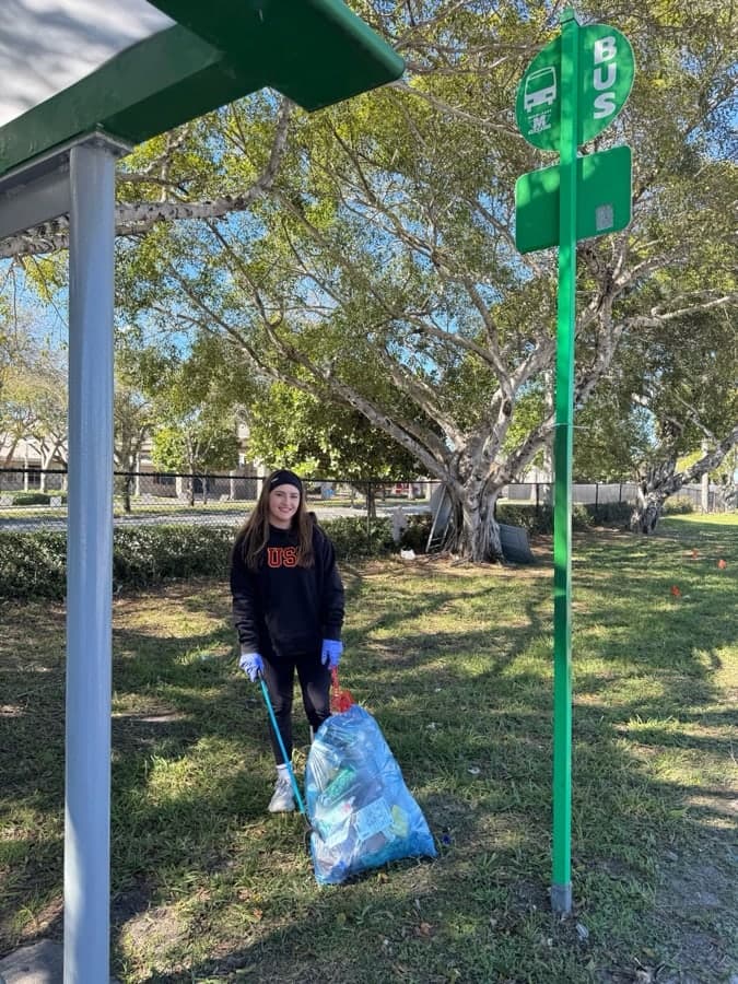 Patricia picking up litter with a trash bag