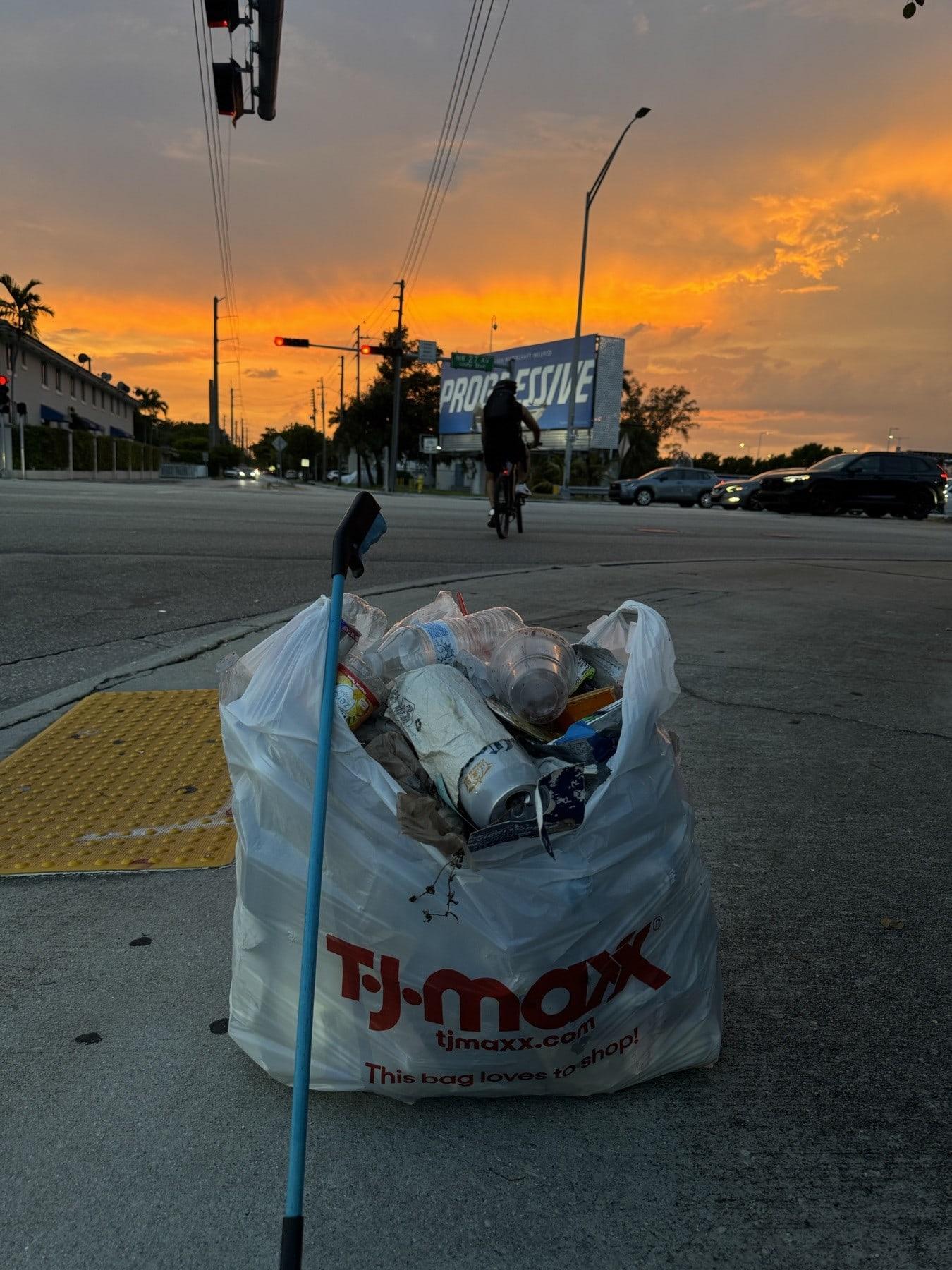 A full bag of litter collected at a busy intersection at sunset
